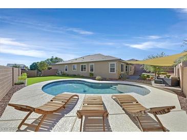 Resort-style backyard with a kidney shaped pool and three lounge chairs offers a perfect space for relaxation and entertainment at 10330 Glacier Mist Ave, Las Vegas, NV 89149