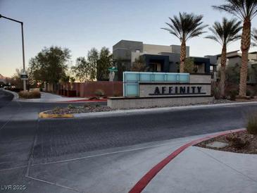 Modern community entrance sign with palm trees and building in background at 11251 Hidden Peak Ave # 212, Las Vegas, NV 89135