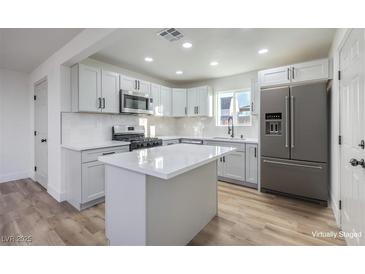 Modern kitchen featuring white shaker cabinets, quartz countertops, and stainless steel appliances at 133 Dogwood St, Henderson, NV 89015