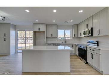 Modern kitchen with island, stainless steel appliances, and light gray cabinets at 4962 E Baltimore Ave, Las Vegas, NV 89104