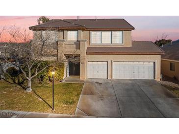 Two-story house with three-car garage, balcony, and landscaping at 8728 Burning Hide Ave, Las Vegas, NV 89143