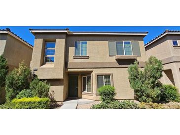 Tan two-story house with green shutters and landscaping at 9490 Alma Ridge Ave, Las Vegas, NV 89178