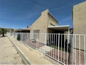 Back exterior view of single story home with covered patio and fenced yard at 2235 High Dunes Ln, Laughlin, NV 89029