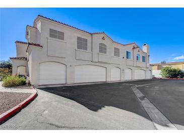 Exterior view of a multi-unit residential building with attached garages at 6821 Santa Isabel Ave # 104, Las Vegas, NV 89146