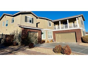 Two-story house with brick and siding, two-car garage, and landscaped yard at 7458 Mezzanine View Ave, Las Vegas, NV 89178