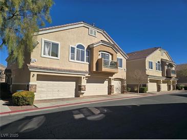 Tan two-story townhouses with attached garages and balconies at 1142 Grass Pond Pl # 3, Henderson, NV 89002