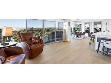 Bright living room featuring cozy armchairs, hardwood floors, and floor to ceiling windows with a scenic view at 3111 Bel Air Dr # 7F, Las Vegas, NV 89109