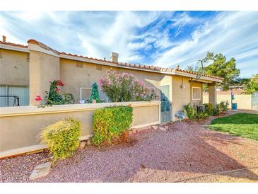 Private backyard with small patio, flowering plants, and gravel landscaping at 3262 Mystic Ridge Ct, Las Vegas, NV 89129