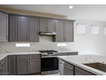 Modern kitchen features gray cabinets, stainless steel appliances and quartz countertops at 4119 Amberdale Ave, North Las Vegas, NV 89031