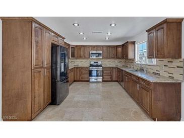 Spacious kitchen features granite countertops, stainless steel appliances, and ample cabinet space at 7220 Stormson Dr, Las Vegas, NV 89145