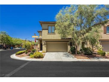 Tan two-story home with attached garage and landscaped yard at 7611 Phoenix Peak St, Las Vegas, NV 89166