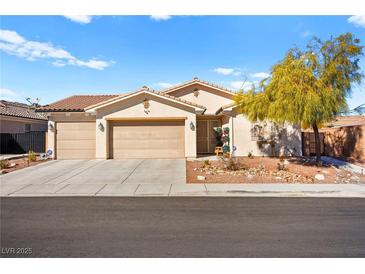 Single-story house with three-car garage, landscaping, and desert landscaping at 2134 Dillons Cove Dr, Laughlin, NV 89029