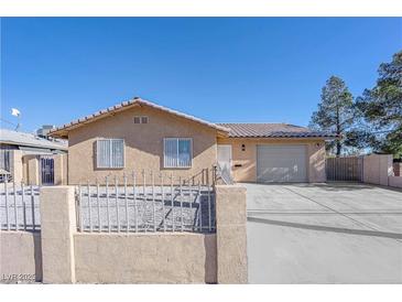 Beige house with gray garage door and metal fence at 4450 Mountain Vista St, Las Vegas, NV 89121