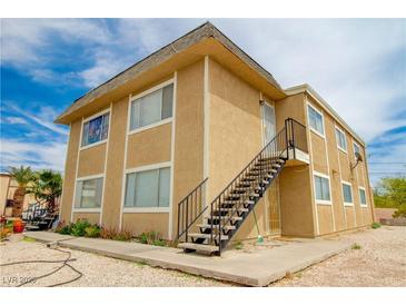 Tan stucco building with stairs leading to the second level under a sunny sky at 523 Fir St, Boulder City, NV 89005
