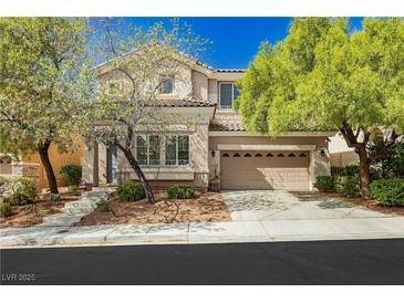 Charming two-story home with a well-manicured front yard, mature trees, and a two-car garage at 561 Tecate Valley St, Las Vegas, NV 89138
