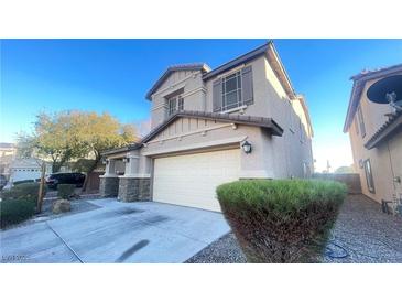 Two-story house with stone accents, attached garage, and landscaping at 59 Dreamy Hill Ave, North Las Vegas, NV 89031