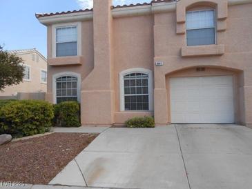 Charming two-story home featuring a stucco facade, arched windows, a two-car garage, and a well-maintained front yard at 8441 Blue Island Ave, Las Vegas, NV 89129