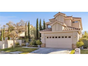 Two-story house with tan exterior, tile roof, and landscaped yard at 1352 Fox Acres Dr, Las Vegas, NV 89134