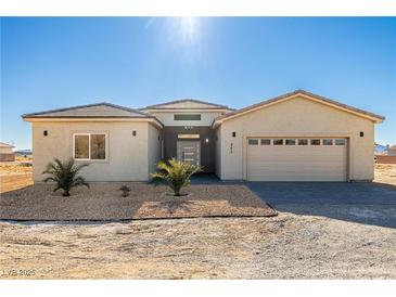 Single-story house with light beige exterior, two-car garage, and landscaping at 251 Glenoaks St, Pahrump, NV 89048