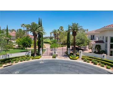 Grand estate entrance with gated community, lush landscaping, and palm trees at 66 Innisbrook Ave, Las Vegas, NV 89113