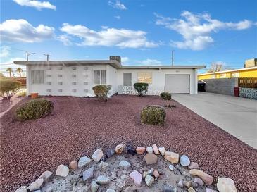 Ranch style home with attached garage and landscaped yard at 1819 Bassler St, North Las Vegas, NV 89030