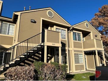 Tan two-story building with stairs and landscaping at 4672 Krissylouise Way, Las Vegas, NV 89121