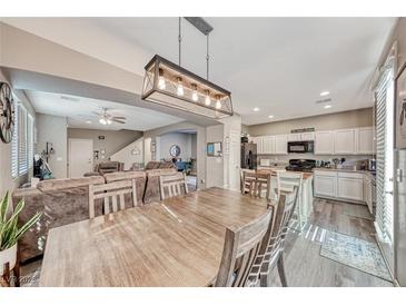 Bright dining area with a large wooden table, seamlessly connects to the living room and kitchen area at 5428 Brazelton St, North Las Vegas, NV 89081