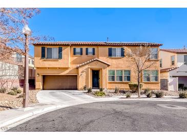 Two-story house with tan siding, brown garage door, and landscaping at 5428 Brazelton St, North Las Vegas, NV 89081