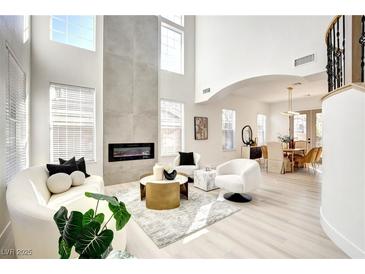 Bright living room with soaring ceilings, modern fireplace, and sleek, contemporary furnishings at 5737 Heather Breeze Ct, Las Vegas, NV 89141