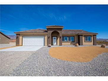 Charming single-story home with a two-car garage and low-maintenance desert landscaping at 5821 Genoa Ave, Pahrump, NV 89060