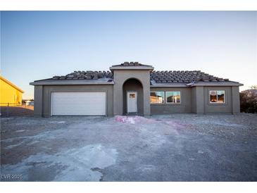 New single-story home with attached garage and arched entryway at 801 Fort Churchill Rd, Pahrump, NV 89060