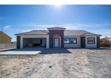 Charming single-story home featuring a neutral color scheme, an attached garage, and contemporary architectural details at 801 Fort Churchill Rd, Pahrump, NV 89060