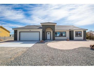 Beautiful single-story home featuring a two-car garage and desert landscaping at 801 Fort Churchill Rd, Pahrump, NV 89060