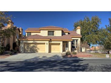 Two-story house with tan exterior, tile roof, and two-car garage at 8916 Stafford Springs Dr, Las Vegas, NV 89134