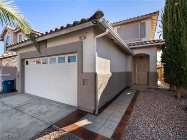 Two-story house with a white garage door and a landscaped walkway at 9523 Cherrydale Ct, Las Vegas, NV 89147