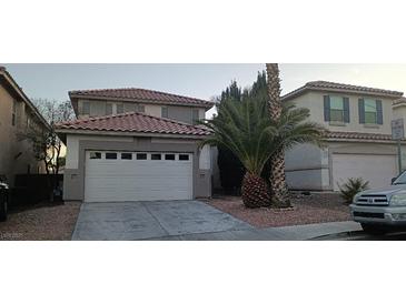 Two-story house with a white garage door and a palm tree in front at 9523 Cherrydale Ct, Las Vegas, NV 89147