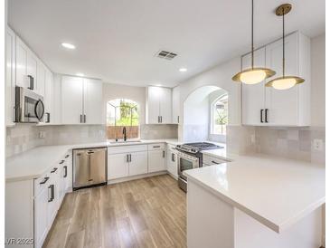 Modern kitchen with white cabinets, stainless steel appliances, and quartz countertops at 10968 Fintry Hills St, Las Vegas, NV 89141