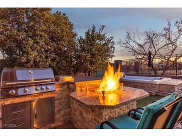 Outdoor kitchen, fire pit, and hot tub create a relaxing backyard oasis at 138 Reflection Cove Dr, Henderson, NV 89011