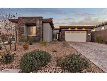 Beautiful single-story home with stone accents, desert landscaping, and a two-car garage at 138 Reflection Cove Dr, Henderson, NV 89011