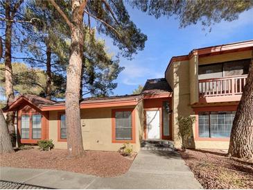 Tan two-story condo with red accents and walkway at 2386 Pickwick Dr, Henderson, NV 89014