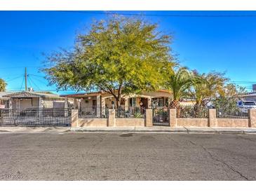 Ranch style home with mature trees and a gated front yard at 2608 Spear St, North Las Vegas, NV 89030