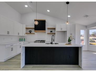 Modern kitchen boasts white cabinets, a large island, and a sleek range hood at 2905 Legend Dr, Las Vegas, NV 89134