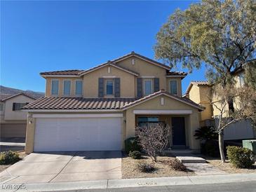 Tan two-story house with tile roof, two-car garage, and landscaping at 3929 Bayamon St, Las Vegas, NV 89129