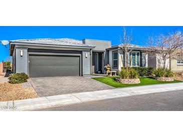 Single-story home with gray garage door and landscaped yard at 4720 E Cactus Canyon Dr, Pahrump, NV 89061