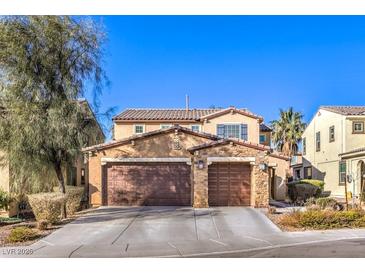 Two-story house with three-car garage, stone accents, and landscaping at 6737 Fast Brook Ct, North Las Vegas, NV 89084