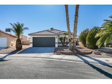 Single story home with a two car garage and desert landscaping at 7305 Backstretch Ave, Las Vegas, NV 89130