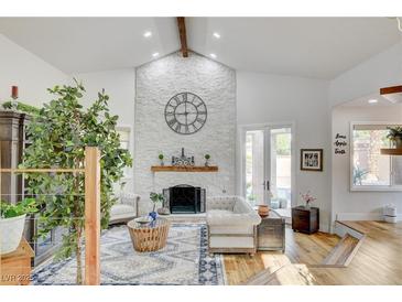 Spacious living room features a stone fireplace, high ceilings, and hardwood floors at 7536 Spanish Bay Dr, Las Vegas, NV 89113