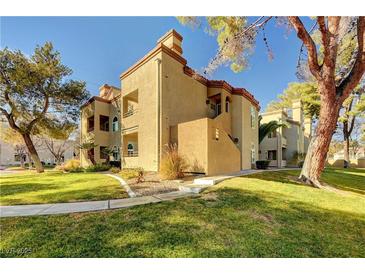 Tan two-story building with grassy lawn and mature trees at 3145 E Flamingo Rd # 2122, Las Vegas, NV 89121