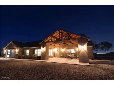 Night view of a single-story home with a covered porch and well-lit entryway at 8068 Buena Vida St, Las Vegas, NV 89166