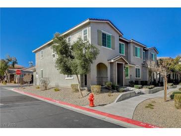 Two-story townhome with gray siding, landscaping, and a walkway at 8486 Insignia Ave # 101, Las Vegas, NV 89178